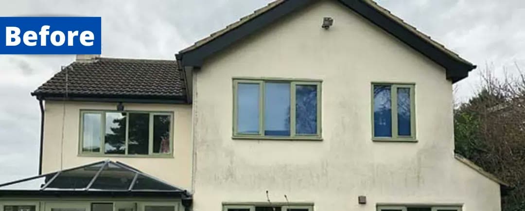 A rendered house with grey, stained walls, before wall coating